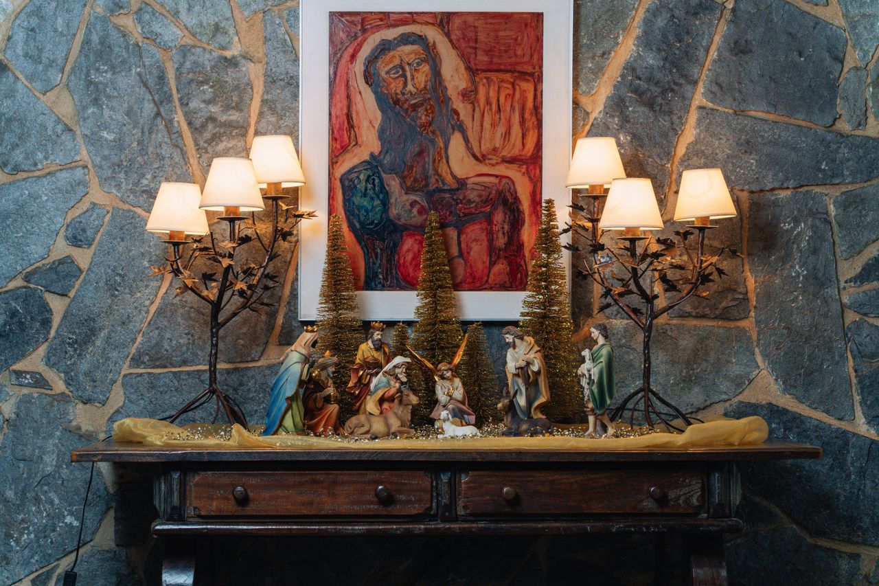 Home A cozy indoor display featuring a nativity scene, festive lamps, and artful decor.