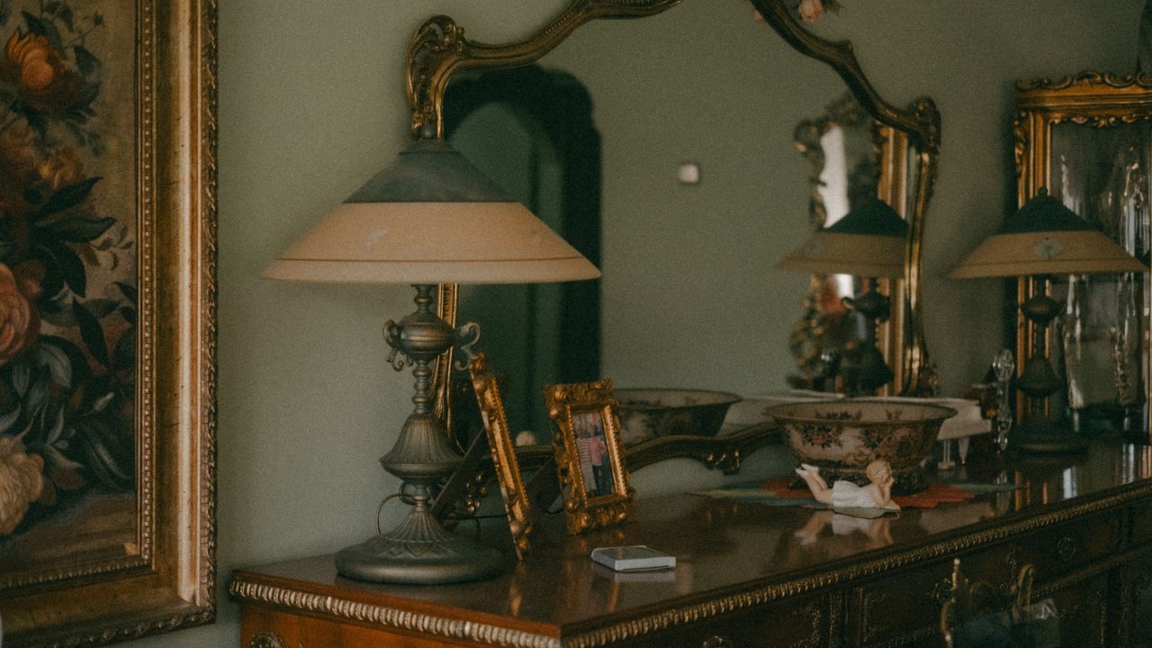 Home Vintage interior design featuring ornate mirrors, an antique lamp, and a wooden cabinet in Eskişehir, Türkiye.