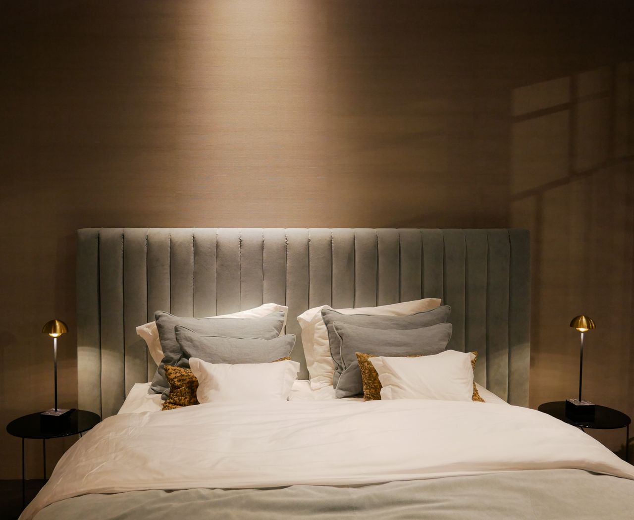 Home Stylish bedroom setup featuring a plush bed and elegant bedside lamps.