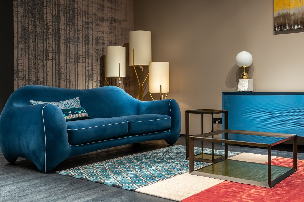 Home Elegant interior design featuring a blue sofa and contemporary decor elements.