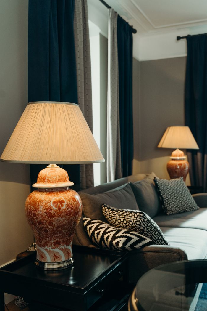 A stylish living room featuring elegant lamps, patterned cushions, and plush seating.